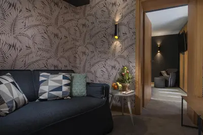 a living room with a couch and a wall at Rosslyn Thracia Hotel Sofia in Sofia