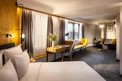 a hotel room with a bed and a desk at Rosslyn Thracia Hotel Sofia in Sofia