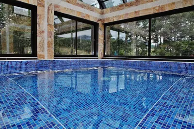 a swimming pool in a house with windows at SPA Hotel Infinity Park Velingrad in Velingrad