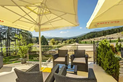 a patio with chairs and a table with an umbrella at SPA Hotel Infinity Park Velingrad in Velingrad