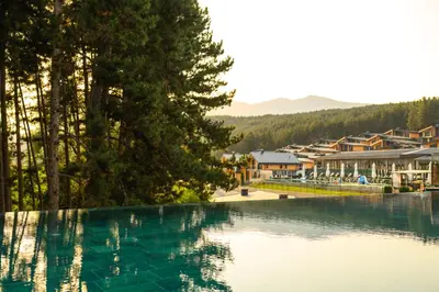 a swimming pool in a resort with trees and houses at SPA Hotel Infinity Park Velingrad in Velingrad