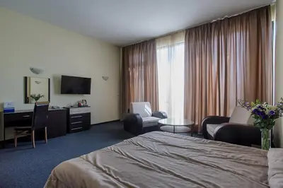 a hotel room with a bed and a desk at Hemus Hotel Sofia in Sofia