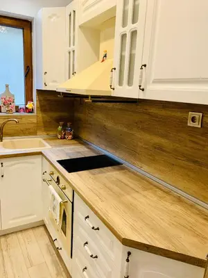 a kitchen with white cabinets and a wooden counter top at Guest House Holiday in Melnik in Melnik