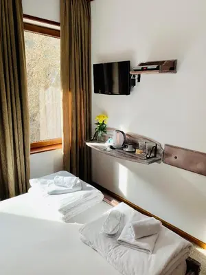 a hotel room with two beds and a shelf on the wall at Guest House Holiday in Melnik in Melnik