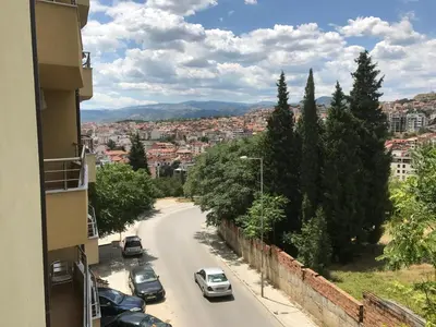 a city street with cars parked on the road at Apartment Elena in Sandanski