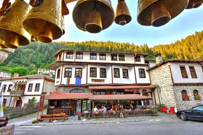 a group of people sitting at a restaurant in front of a building at Hotel Kalina in Shiroka Lŭka