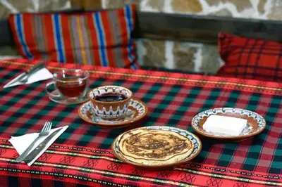a table with plates and cups of coffee on it at Hotel Kalina in Shiroka Lŭka