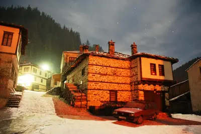 a car parked in front of a building in the snow at Hotel Kalina in Shiroka Lŭka
