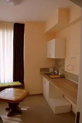 a kitchen with white cabinets and a wooden counter top at Апарт Център Apart Center in Plovdiv