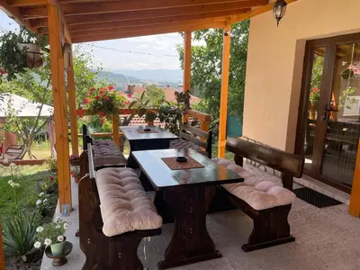 a patio with benches and a table and chairs at Saint Maria Guest House in Velingrad