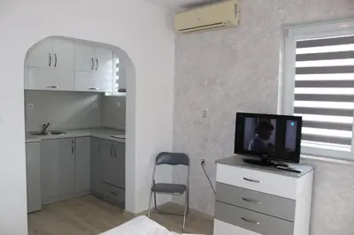 a kitchen with a tv on a dresser with a chair at Saint Maria Guest House in Velingrad