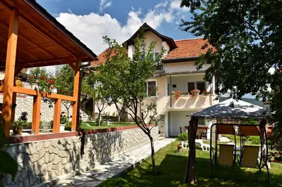 a house with a stone wall and a gazebo at Saint Maria Guest House in Velingrad