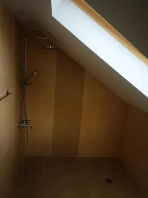 a bathroom with a shower under a roof at Saint Maria Guest House in Velingrad