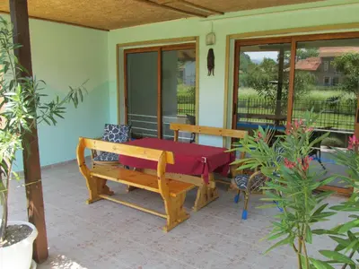 a porch with a bench on a patio at Pri Orehite Guesthouse in Oreshak