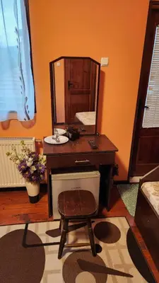 a bathroom with a vanity with a mirror and a stool at Guest House PIP in Velingrad
