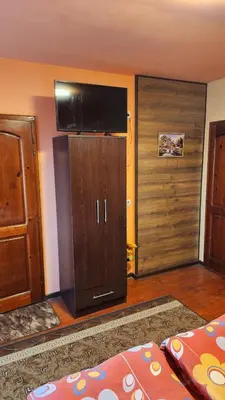 a living room with a television and a closet at Guest House PIP in Velingrad