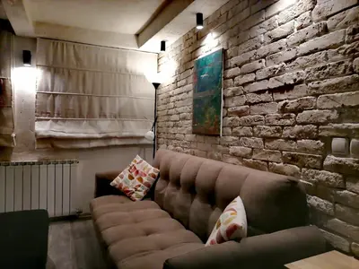 a living room with a couch and a brick wall at Apartments 18 in Velingrad