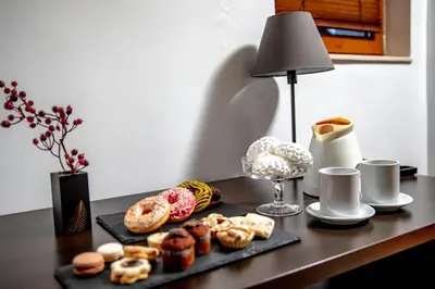 a table with a tray of donuts and a lamp at Velinov Boutique Hotel with Free Shuttle in Bansko