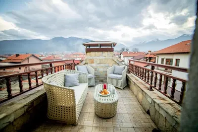 a balcony with chairs and a table on a balcony at Velinov Boutique Hotel with Free Shuttle in Bansko