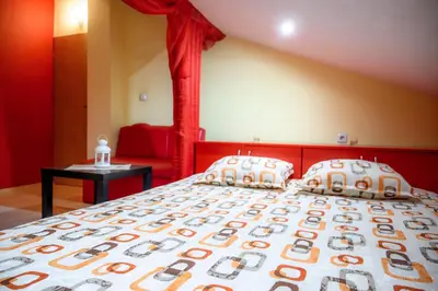 a bedroom with a large bed with a red headboard at Guest House Angelkovi in Sapareva Banya