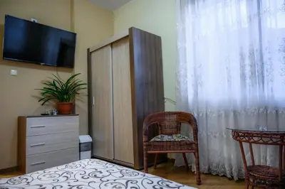 a room with a cabinet and a table and a television at Guest House Angelkovi in Sapareva Banya