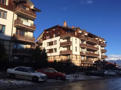 a group of cars parked in front of a building at Apartments Four Leaf Clover Bansko to rent in Bansko