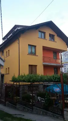 a yellow house with a fence in front of it at Guest House Blisten in Sofia