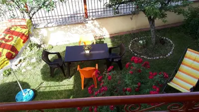 a table and chairs in a garden with flowers at Guest House Blisten in Sofia