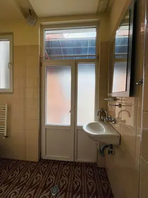 a bathroom with a sink and a door with windows at Rooms43 in Sofia