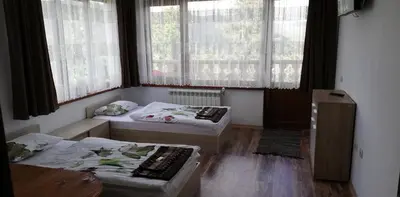 two beds in a room with two windows at EldoSport Hotel in Dospat