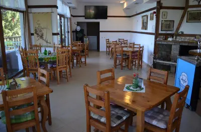 a dining room with wooden tables and chairs at EldoSport Hotel in Dospat
