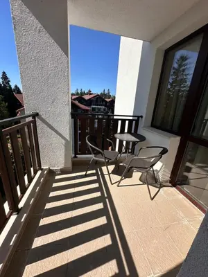 a pair of chairs sitting on the balcony of a house at Alpine luxury two bed-two bathrooms apartment B25 in Borovets