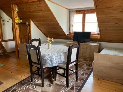 a dining room with a table with chairs and a television at Vila Venera in Velingrad
