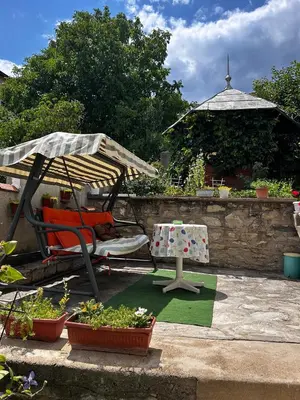 a patio with a chair and an umbrella and some plants at Vila Venera in Velingrad