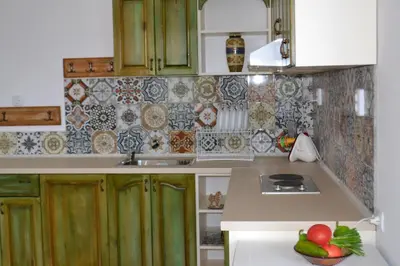 a kitchen with green cabinets and a bowl of fruit on the counter at Vila Venera in Velingrad