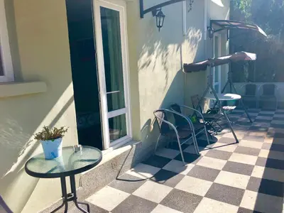 two tables and chairs on a porch with a window at The Bookies Apartments in Sofia