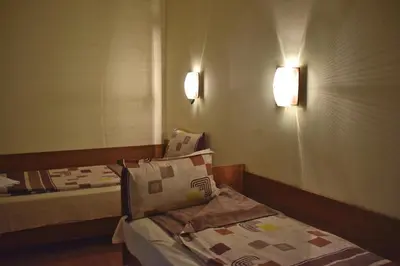 a room with two beds and two lights on the wall at Hotel Jeravna in Bankya
