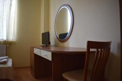 a room with a desk with a mirror and a chair at Hotel Jeravna in Bankya