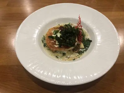 a white plate with a dish of food on a table at Spa Hotel Spartak in Sandanski