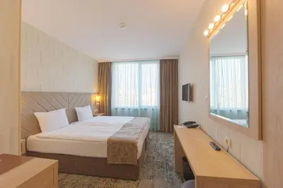 a hotel room with a bed and a mirror at Spa Hotel Spartak in Sandanski