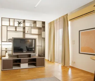 a living room with a flat screen tv on a entertainment center at Deluxe Studio Studentski Grad in Sofia
