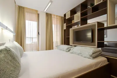 a bedroom with a large bed with a tv on it at Deluxe Studio Studentski Grad in Sofia