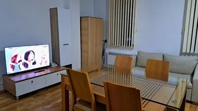 a living room with a glass table and a television at Mountain View A23 in Bansko