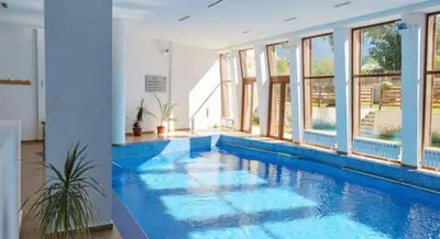 a large swimming pool in a room with windows at Mountain View A23 in Bansko