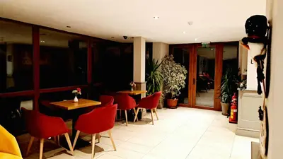 a restaurant with red chairs and tables in a room at Mountain View A23 in Bansko