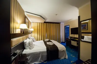 a hotel room with a bed and a mirror at Grand Hotel Hebar in Pazardzhik