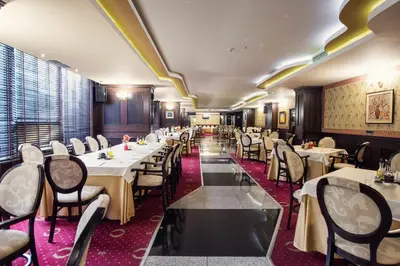 a dining room with white tables and chairs at Grand Hotel Hebar in Pazardzhik