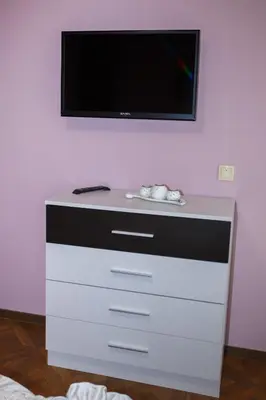 a dresser with a flat screen tv on a wall at Apartment Ira in Velingrad