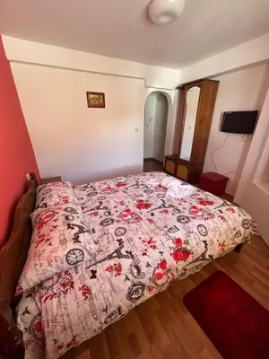a bedroom with a bed with a floral comforter at Yovkovata Kyshta in Chiflik