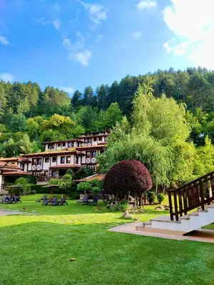 a resort with a park with benches and trees at SPA Hotel Ismena in Devin